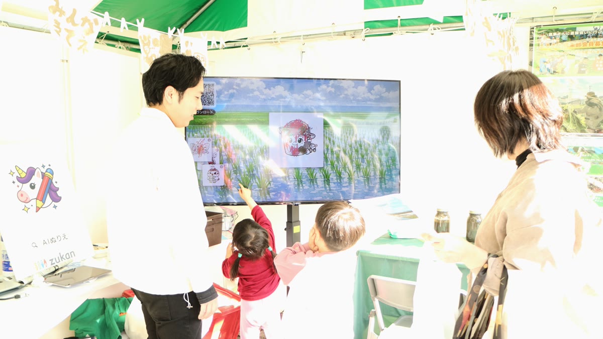 Padres e hijos admirando las obras en el Lienzo de arrozal